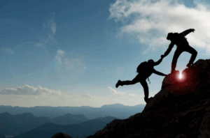Un professionnel en costume aide une autre personne à gravir une marche ou à monter une échelle symbolique, illustrant la notion de progression, de soutien et d’accompagnement. Cette image incarne visuellement la relation de mentorat ou de coaching, où l’un guide l’autre vers un niveau supérieur de développement personnel ou professionnel.