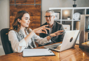 Mentorat en entreprise entre un collaborateur expérimenté et un jeune professionnel, illustrant la transmission de savoir et le développement des talents.